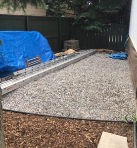 Black plastic edging separating washed rock and mulch